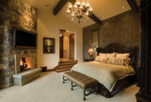 Elegant bedroom with fireplace and chandelier.