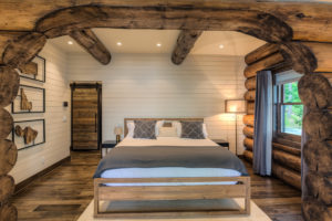 Rustic log cabin bedroom with wooden beams.
