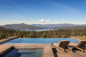 Infinity pool overlooking scenic mountain lake.
