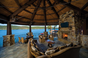 Outdoor lakeside living space with fireplace.