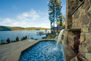 Lakeview pool with waterfall feature and rustic cabin.