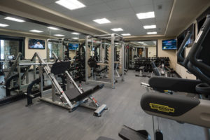 Modern gym with exercise equipment and weights.