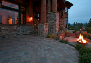 Rustic patio with fire pit and stonework at dusk.