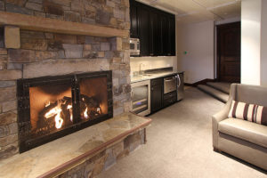 Everwell Bay Remodel Cozy stone fireplace in modern living area.