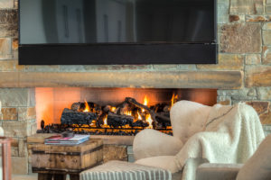 Cozy stone fireplace with burning logs.