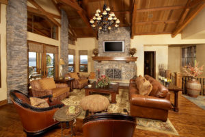 Rustic living room with stone fireplace and leather sofas.
