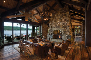 Cozy rustic cabin with lake view and stone fireplace.