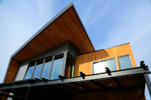 Modern wooden house with large windows.