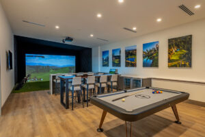 Luxury game room with golf simulator and pool table.