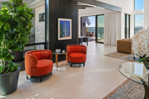 Black Rock Residence #6 Modern living room with red chairs and greenery.