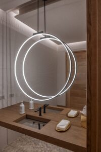 Black Rock Residence #7 Powder room with a sculptural ring light fixture and floating walnut vanity