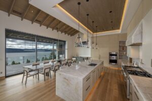 Black Rock Residence #7 Open kitchen and dining space with a reclaimed Douglas fir vaulted ceiling, natural stone island and views of Lake Coeur d'Alene