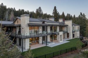 Modern luxury home with stone facade and patio.